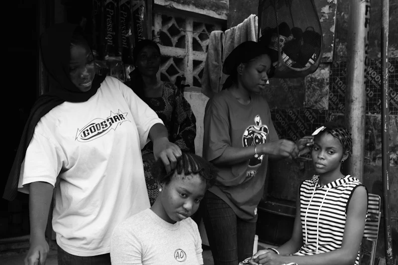 Deux coiffeuses tressent leurs clientes